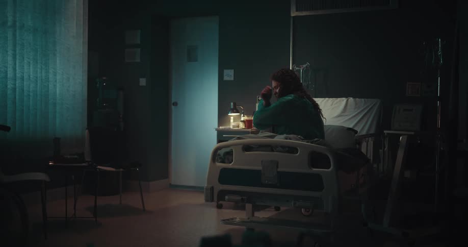 A woman is sitting in a hospital bed and with expressions of loneliness