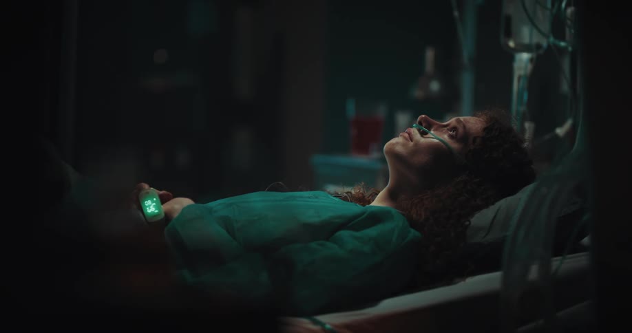 Female patient lying in a hospital bed looking up thoughtfully