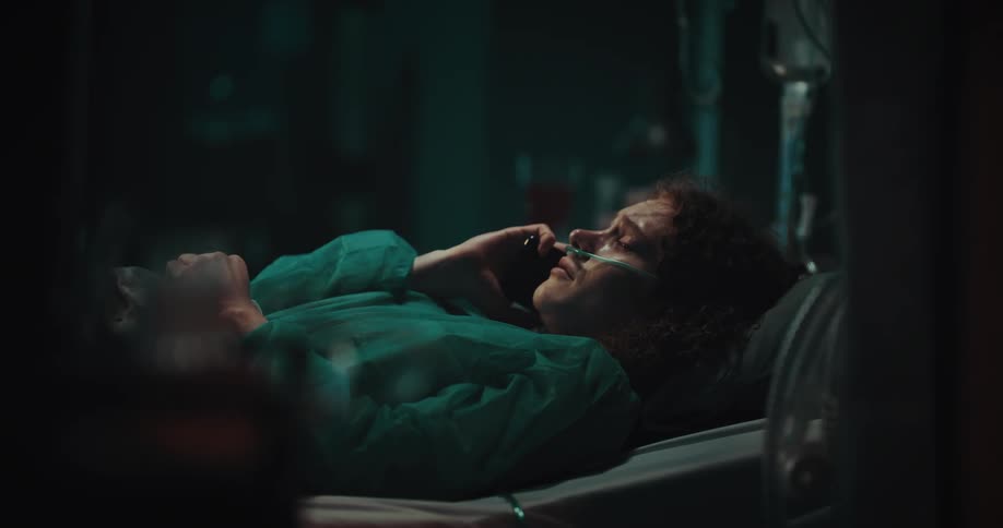 A girl in a hospital bed talking on her cell phone