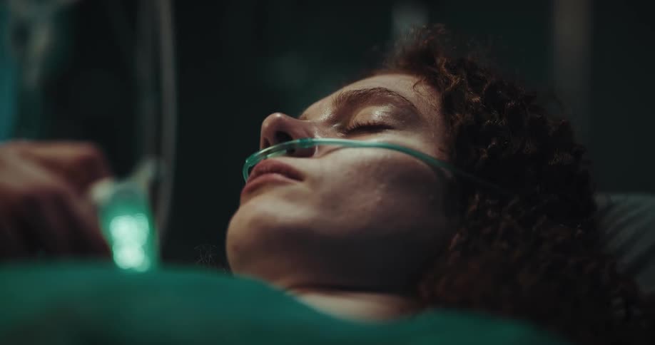 Woman lying in a hospital bed with a sad facial expression closing her eyes