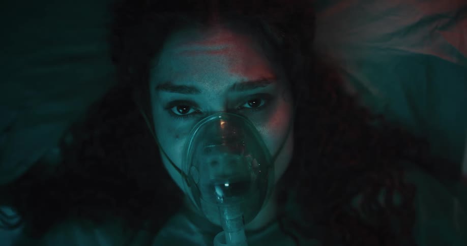 Portrait of a young woman lying down with an oxygen mask