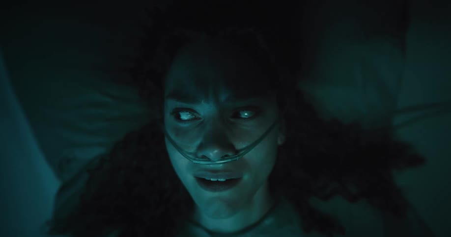Woman touches her nasal oxygen tube and looks around as red and blue lights flash