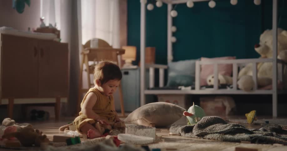 Girl sitting on floor plays with toys