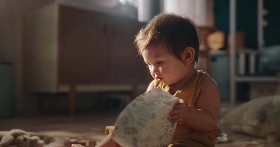 A baby girl is on the floor playing with her toys