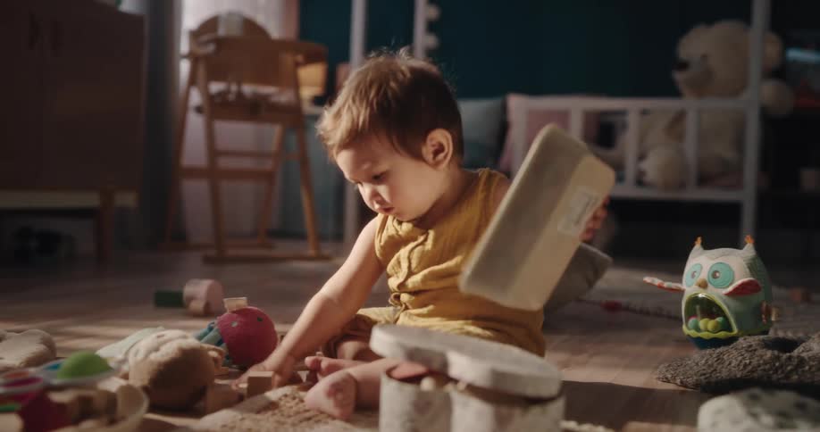 Baby plays with toys on floor at home