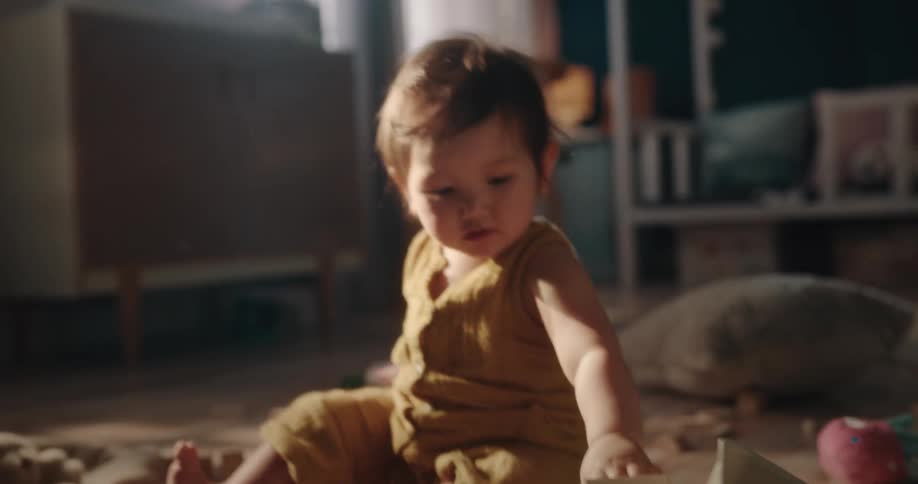 A baby playing with his toys on the bedroom floor