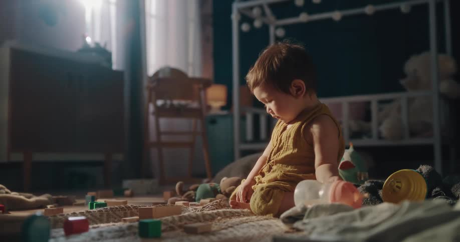 Child takes drink from sippy cup before continuing to play