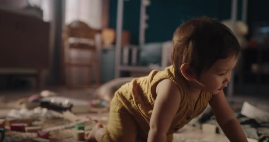 A toddler crawls and plays with toys on the ground