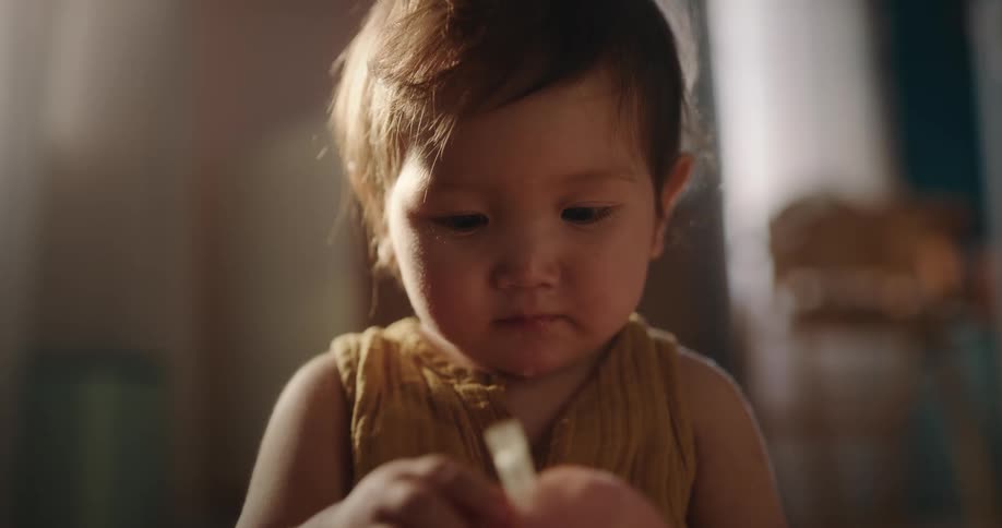Toddler with sticky hands plays with toys at home