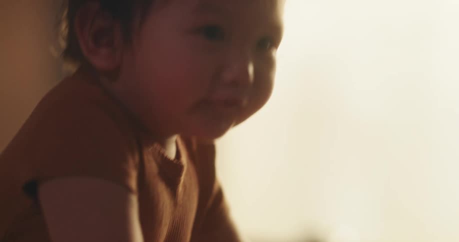 Baby girl standing in the crib with a smile and drooling