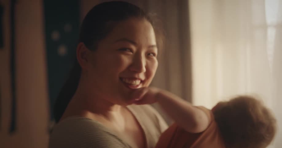 Portrait of a smiling woman holding her baby in her arms