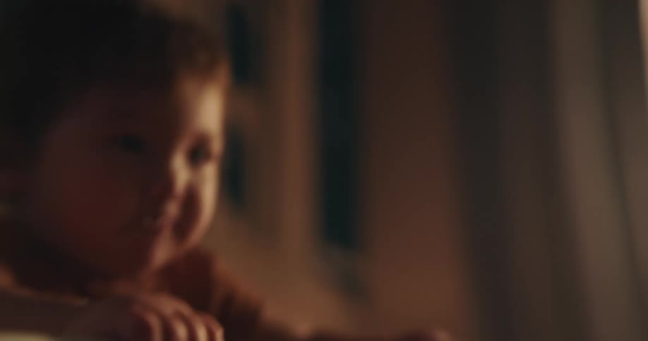 A baby standing in her crib smiling