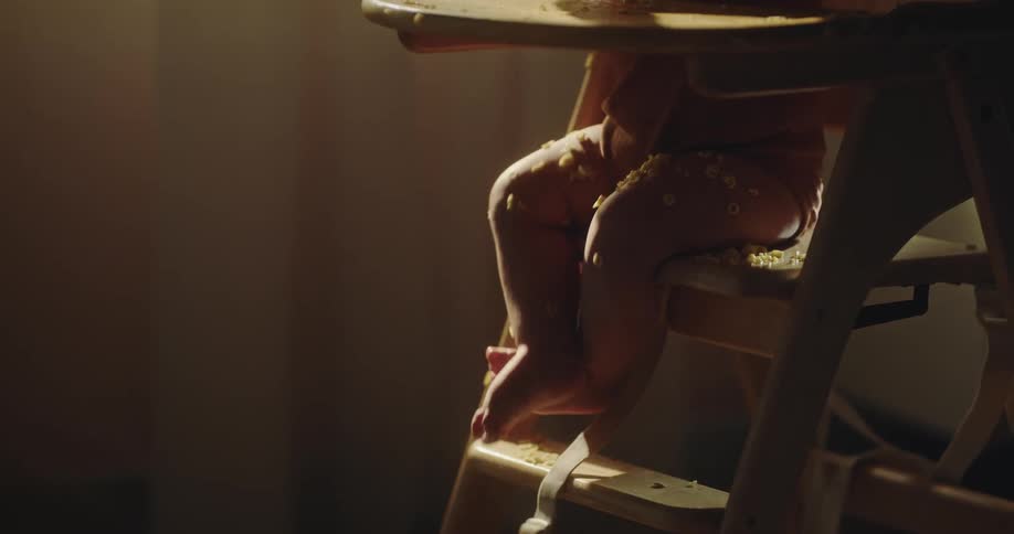 A baby is sitting in a baby high chair