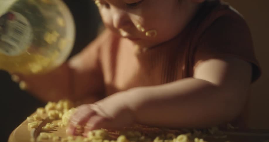 Infant playing with food wastage on the table indoor