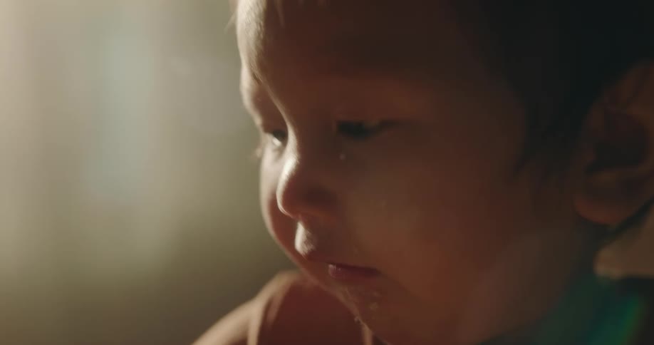 A toddler eating and playing around in a room