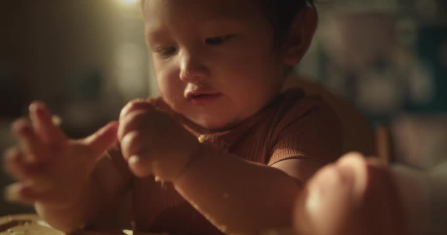 Portrait of a baby playing with food using her hands