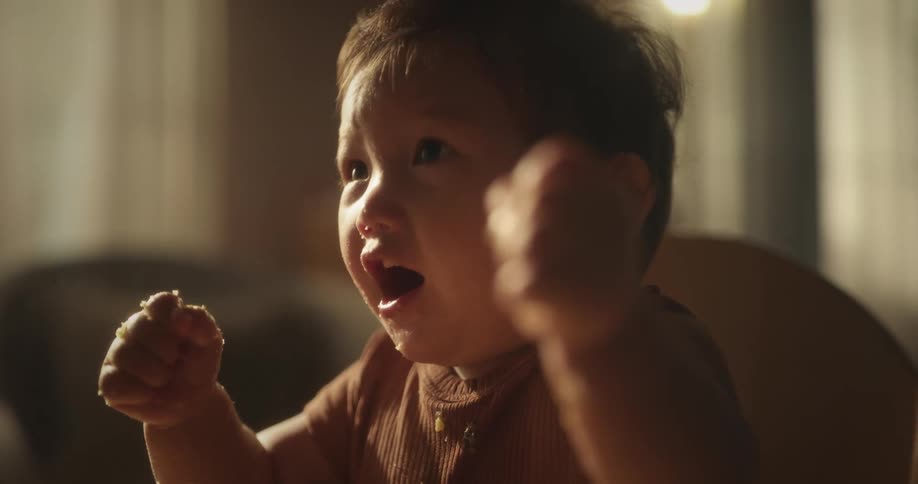 A child clenches fist in excitement inside a room
