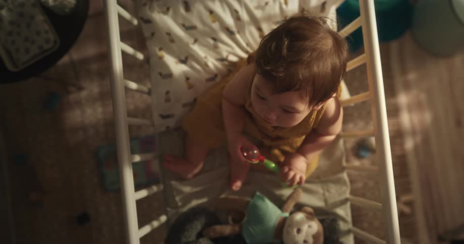 Top down view of a baby inside a crib in the bedroom
