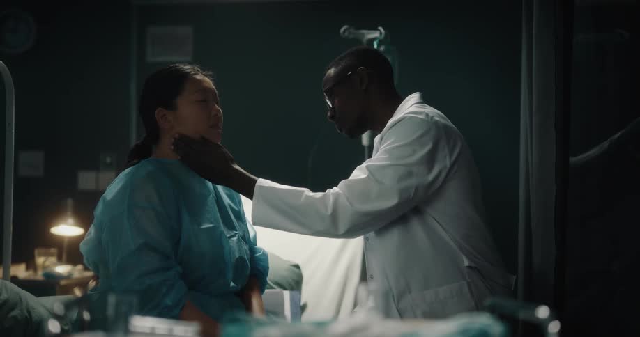 Doctor talking and examining the neck of a patient