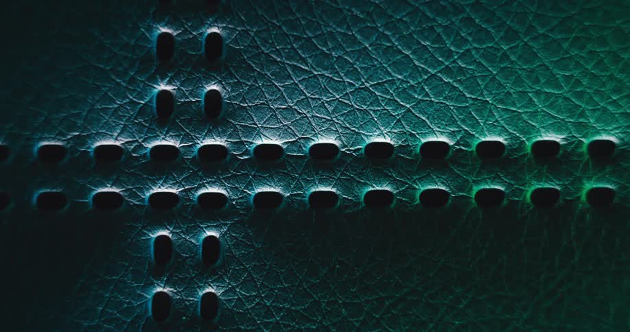 Several holes in lines on a green textured surface