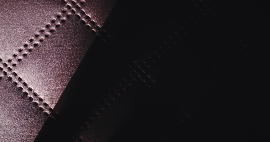 Lights and shadows move over textured brown leather