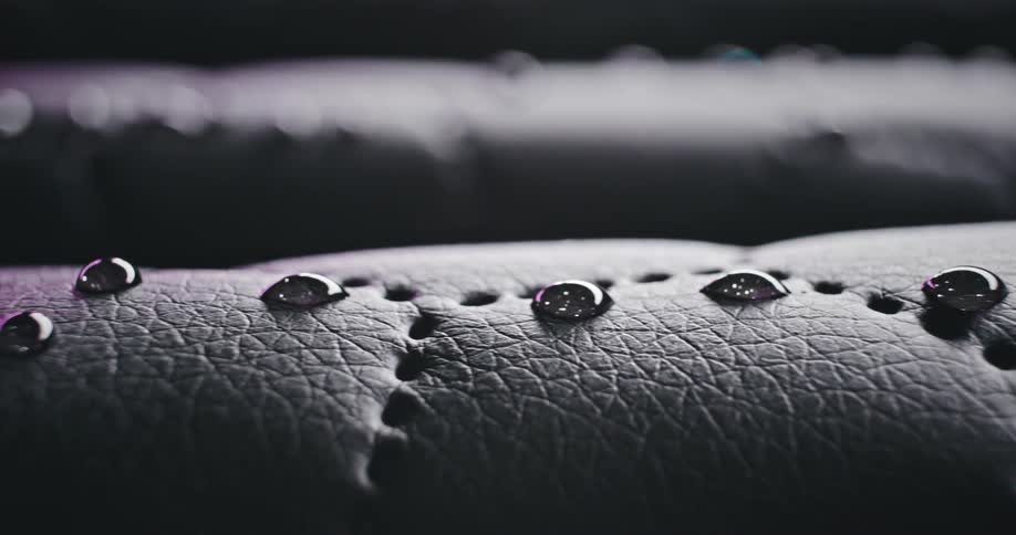 Several drops of a liquid are on a leather surface