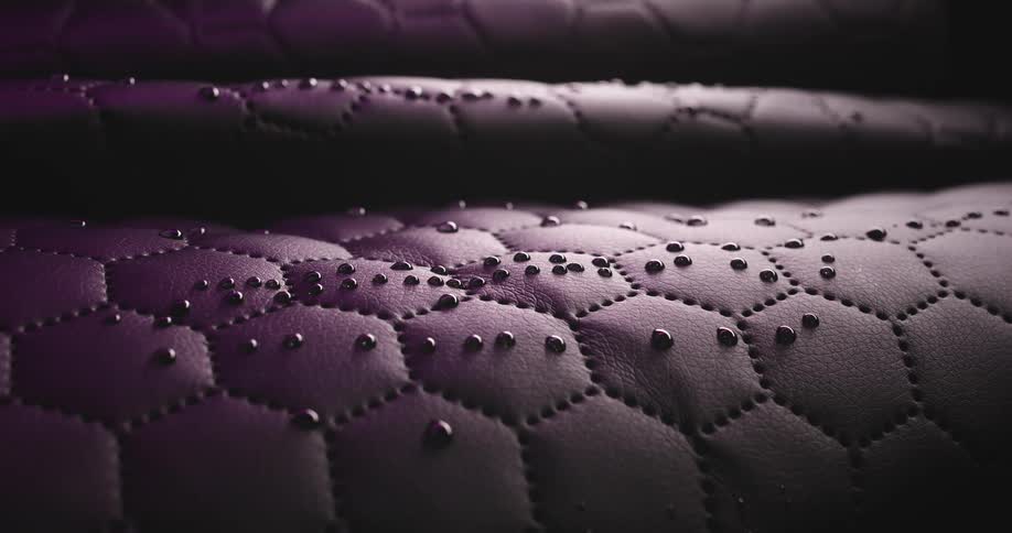 Closeup of dark brown leather with abstract water droplets