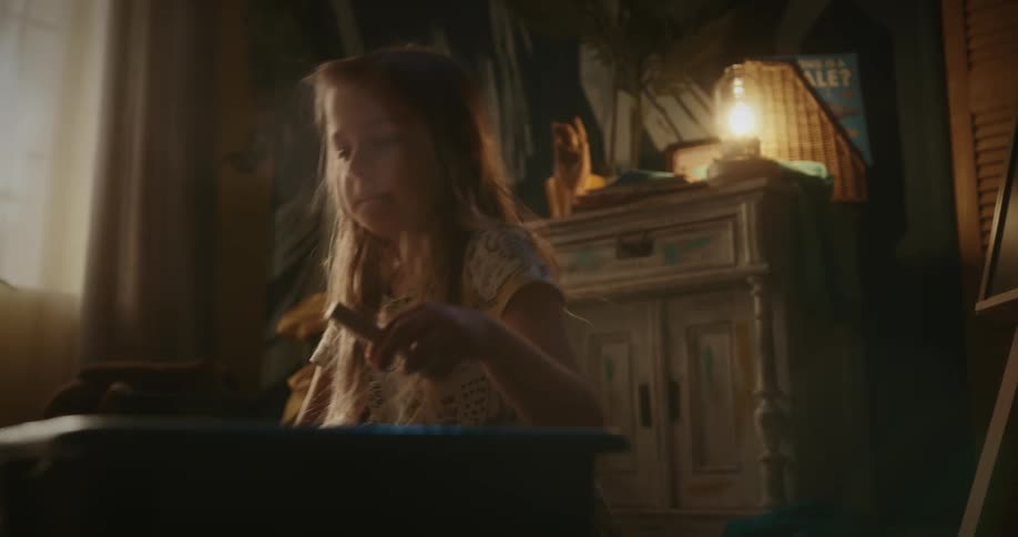 Girl in a room playing with wooden toys and putting them into a box