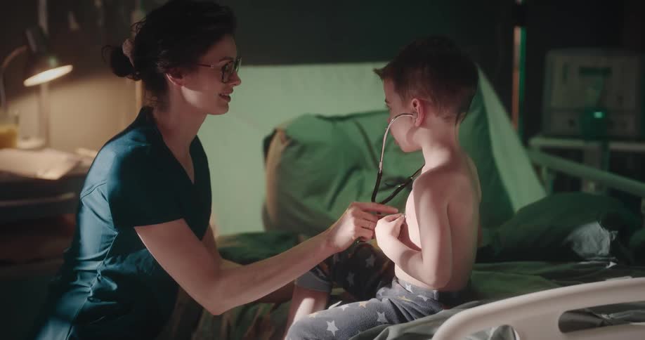 Woman next to a child placing a device to listen to their heartbeat
