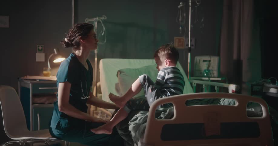 Nurse playfully trying to examine a child who initially refuses then she takes a lollipop from her pocket to capture his attention