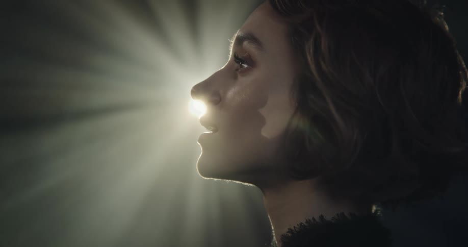 Portrait of a young woman with a happy facial expression and a backlight reflecting on her face