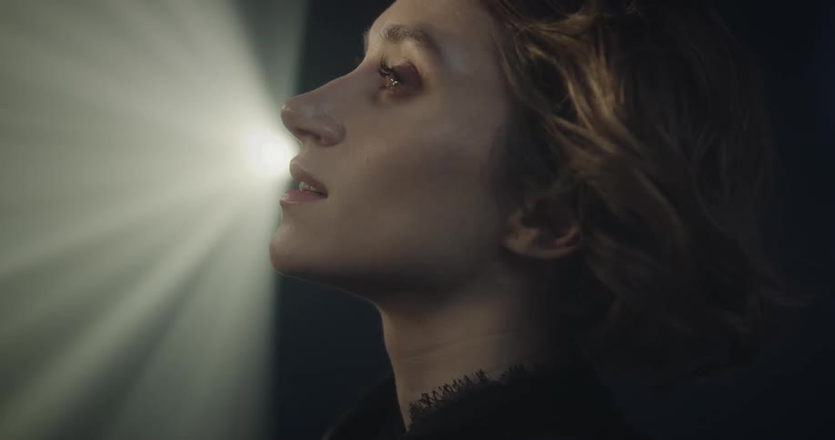 Portrait of a smiling woman with light reflecting on her face