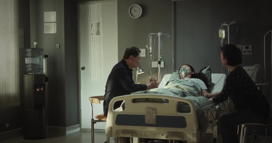 Father and mother visiting their unconscious daughter in the hospital
