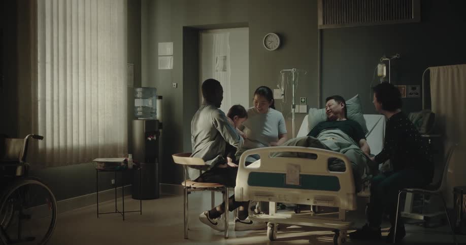 Family around a patient who is lying down and interacting happily