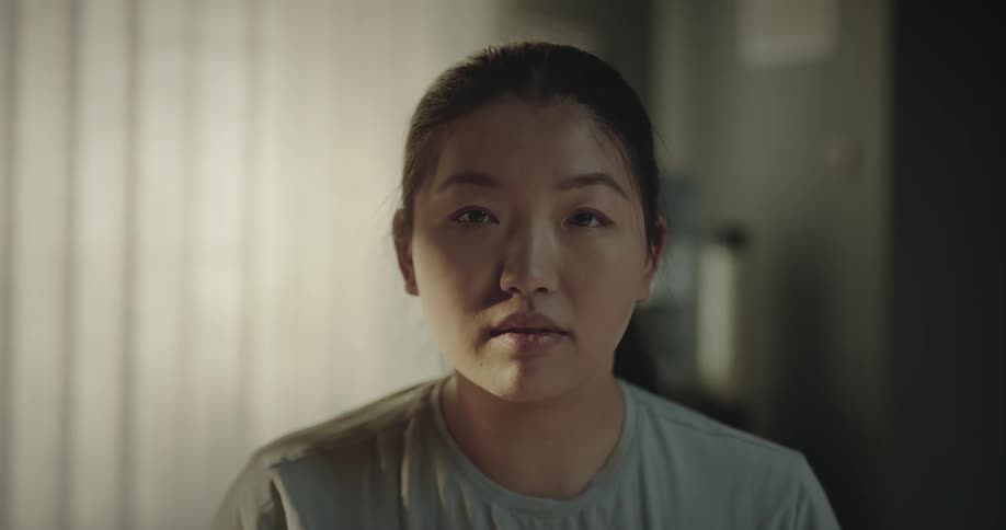 A woman turning a face illuminated by the light from the window