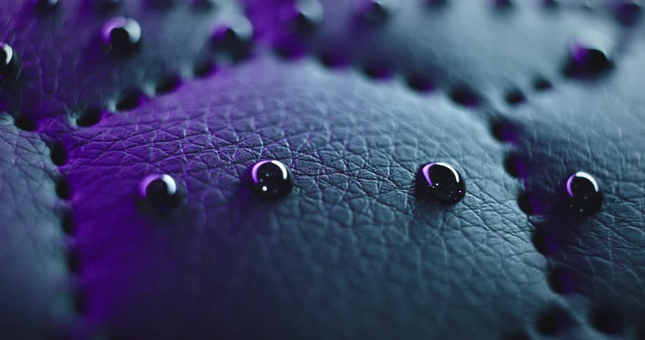 Close up of dark drops of liquid over a textured surface