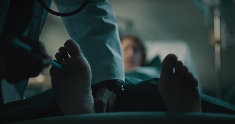 Doctor examines hospital patients feet then sits down to give her good news about her status