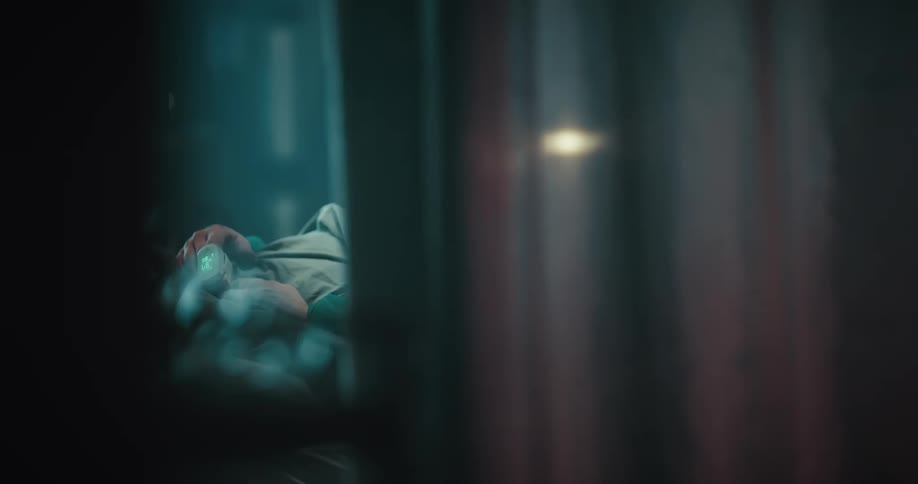 Hands of person lying in bed as seen through curtain