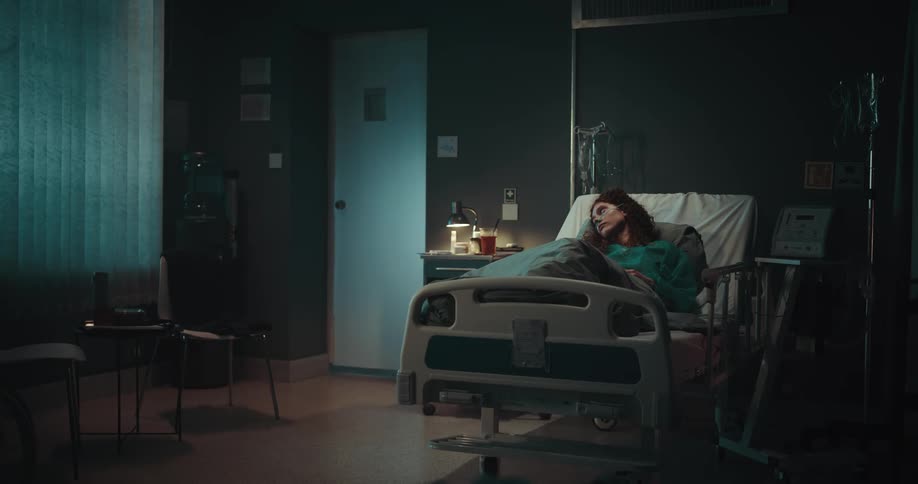 A woman is lying in a hospital bed and sleeping
