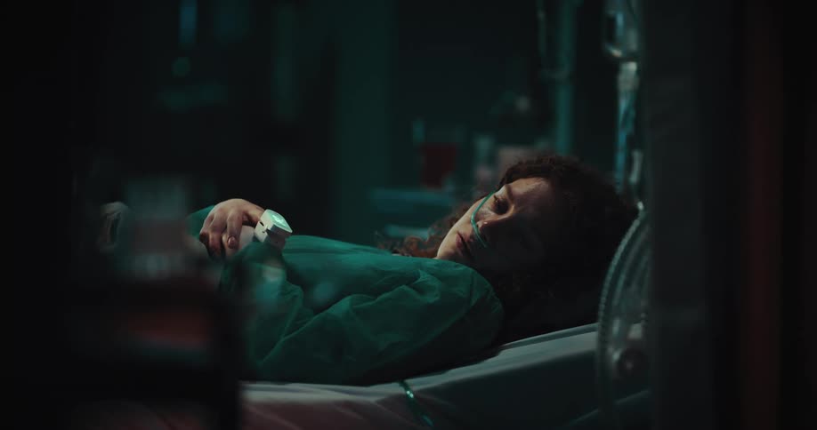 A crying woman lying in a hospital bed