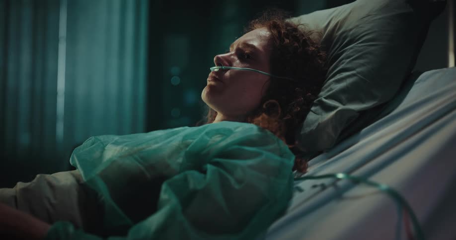 A female hospital patient is lying down with equipment on her body and face