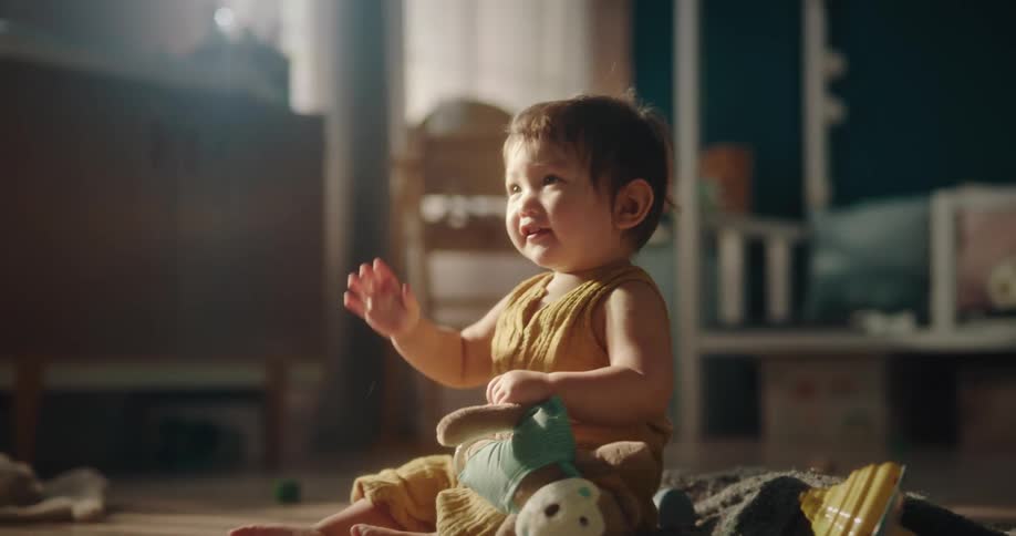 Baby girl playing with a plush toy and becoming happy