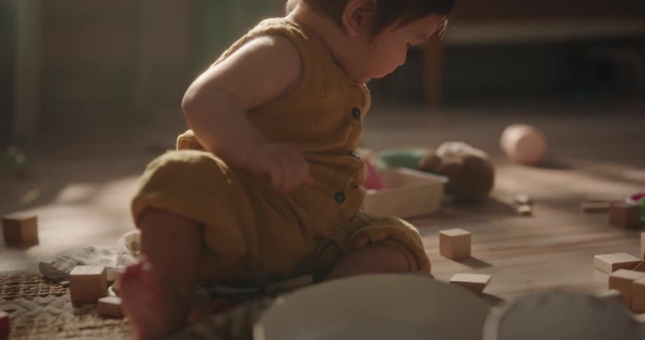 A baby playing on the floor with his toys