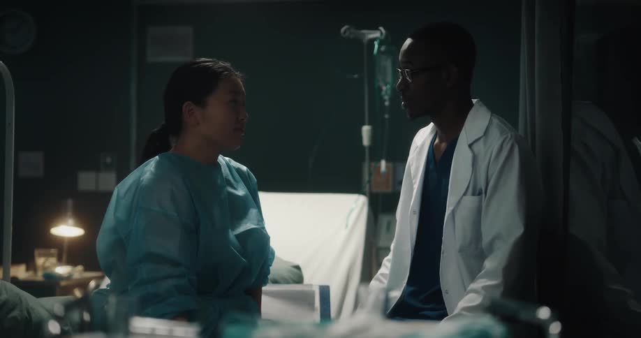 Doctor consulting a patient who is sitting in bed at the hospital