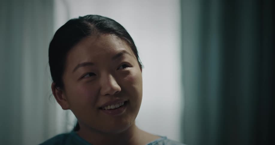 A caregiver smiles and talks while in the hospital