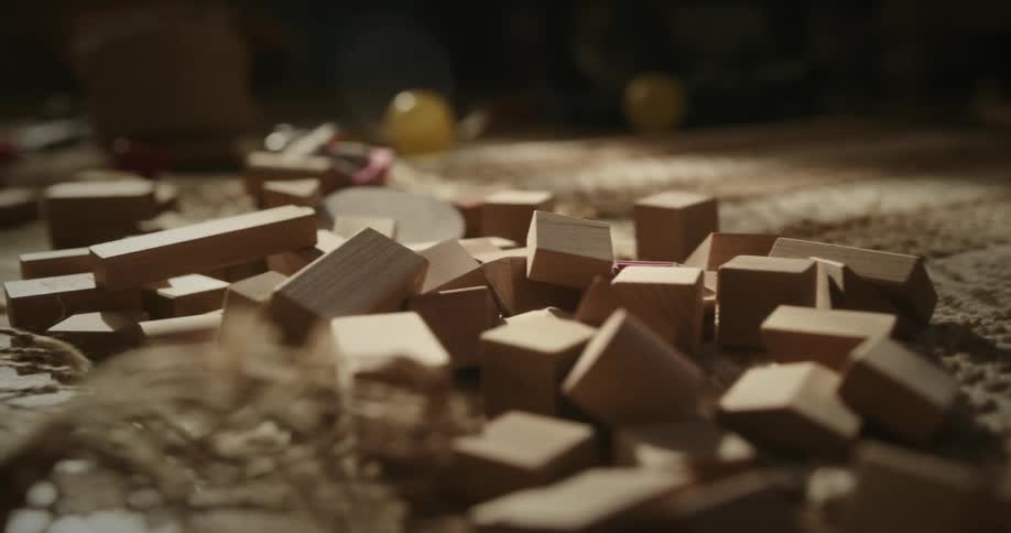 Closeup of a childs hands picking up toys from the floor