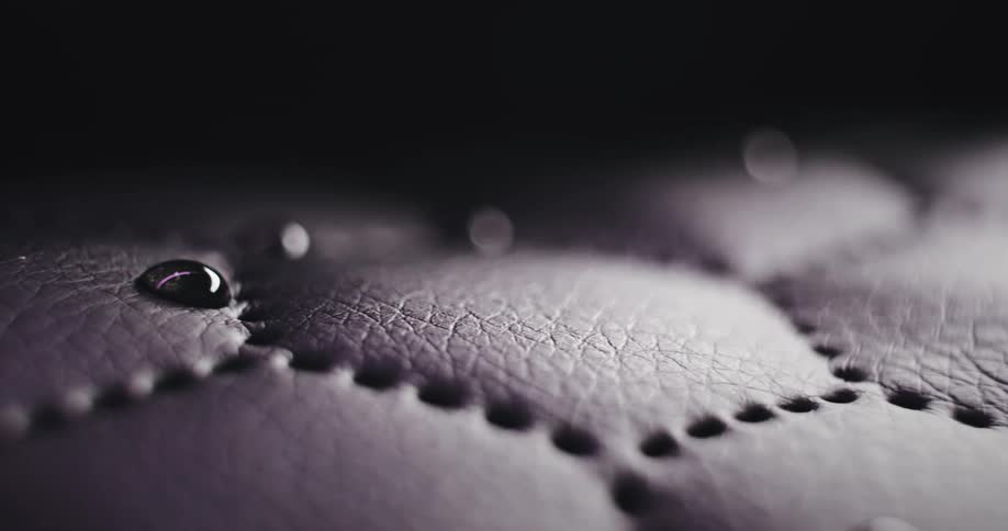 Closeup of water droplets on dark brown leather