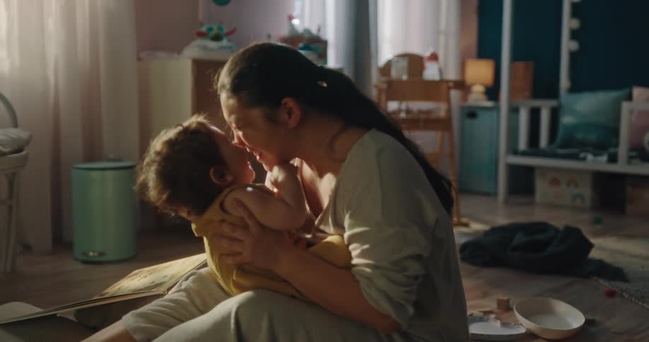A mother hugging and kissing her little daughter