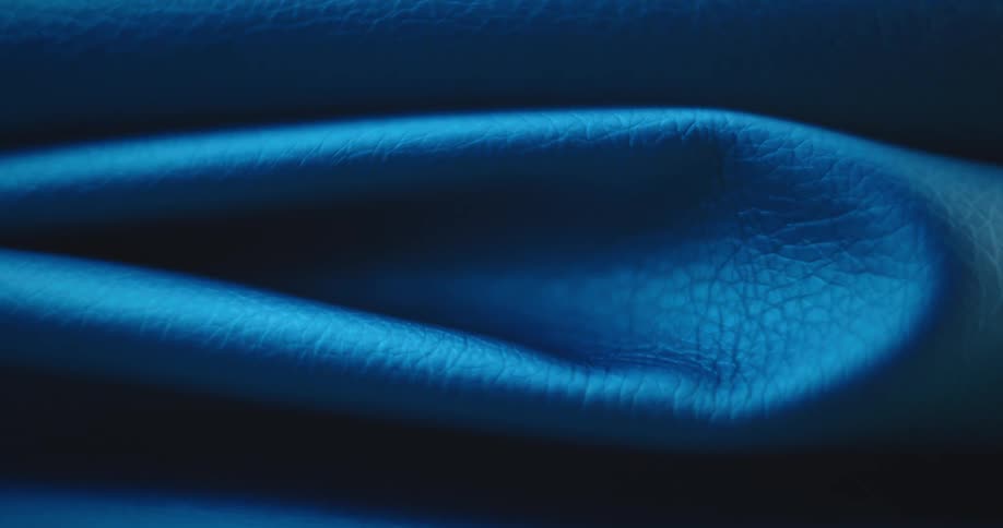Light brightens revealing folded textured blue fabric