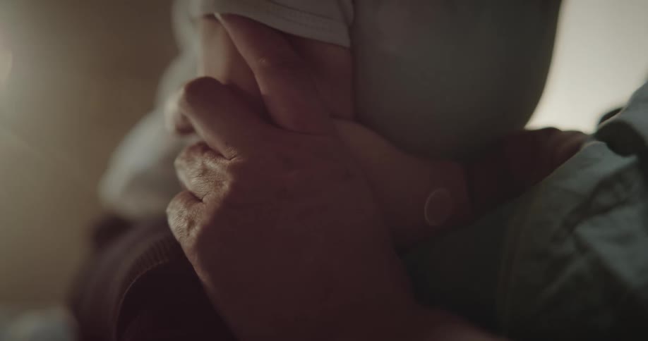 Closeup on the arms of a person holding a baby